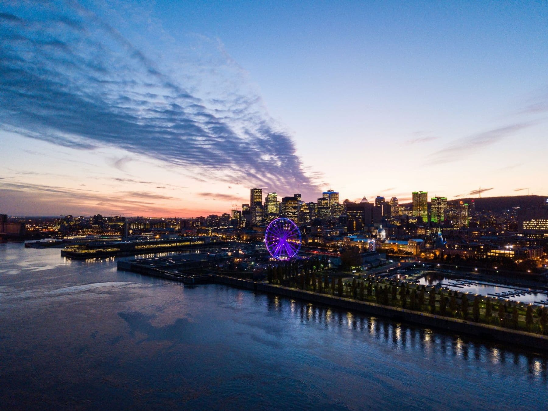 Montreal's Old Port and the Great Wheel at sunset, seen from the river.
